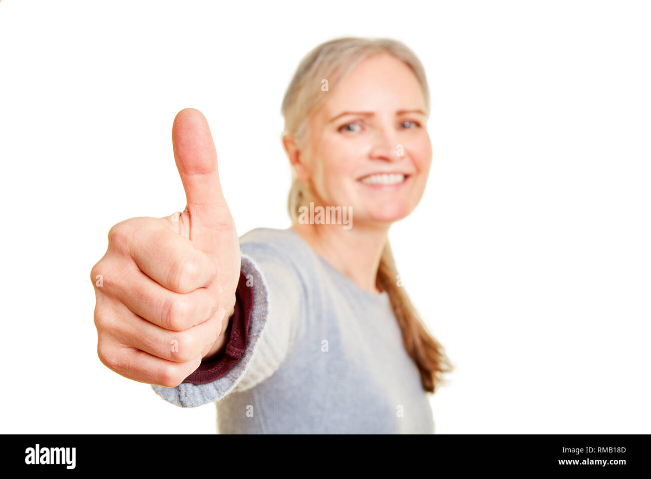 Elderly woman is smiling and holding up her thumb Stock Photo