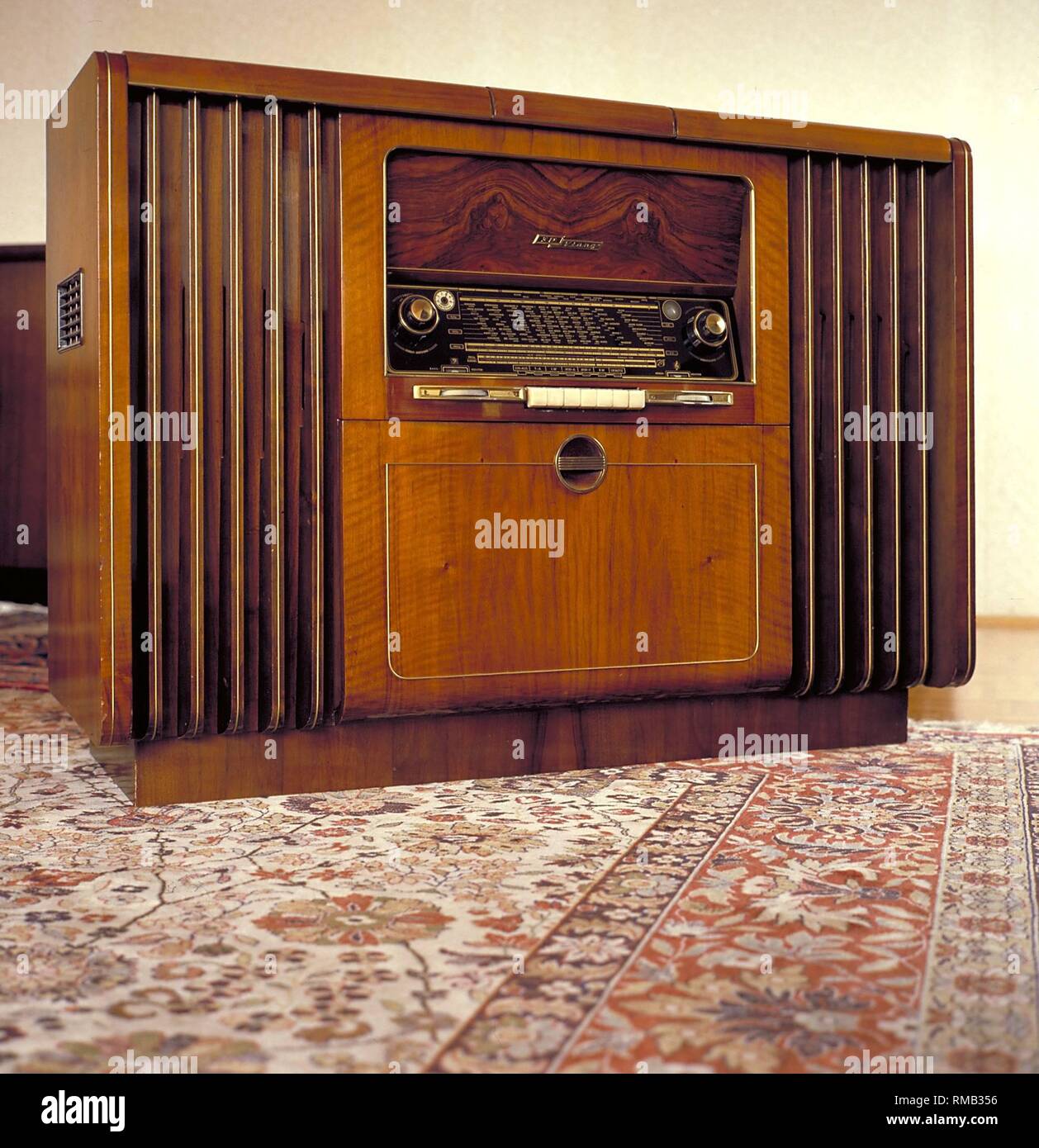 Media: Radio-phonograph of the company Grundig from the early 50s. In the compartment under the radio there is room for a lot of records, on top to the left, the frame can be tilted up, the turntable and on the right, the tape recorder. Stock Photo
