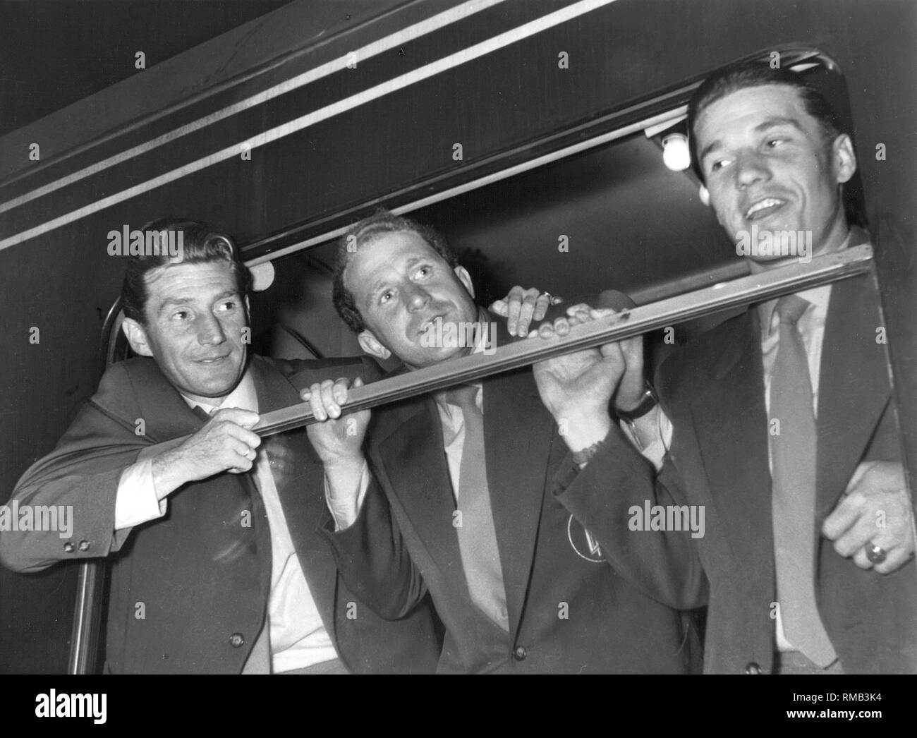 Arrival of the crew at the station in Lindau. Fritz and Ottmar Walter (from left) and another player lean out of the train window. In 1954 Germany won its first World Cup in Switzerland. Stock Photo
