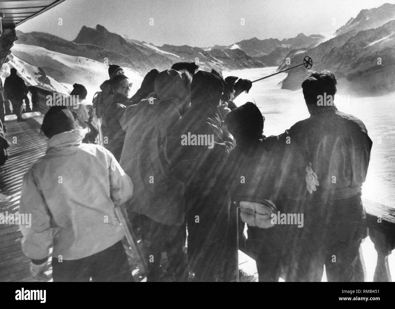 Tourists look from the Jungfrau Observatory to the Bernese Highlands Stock Photo