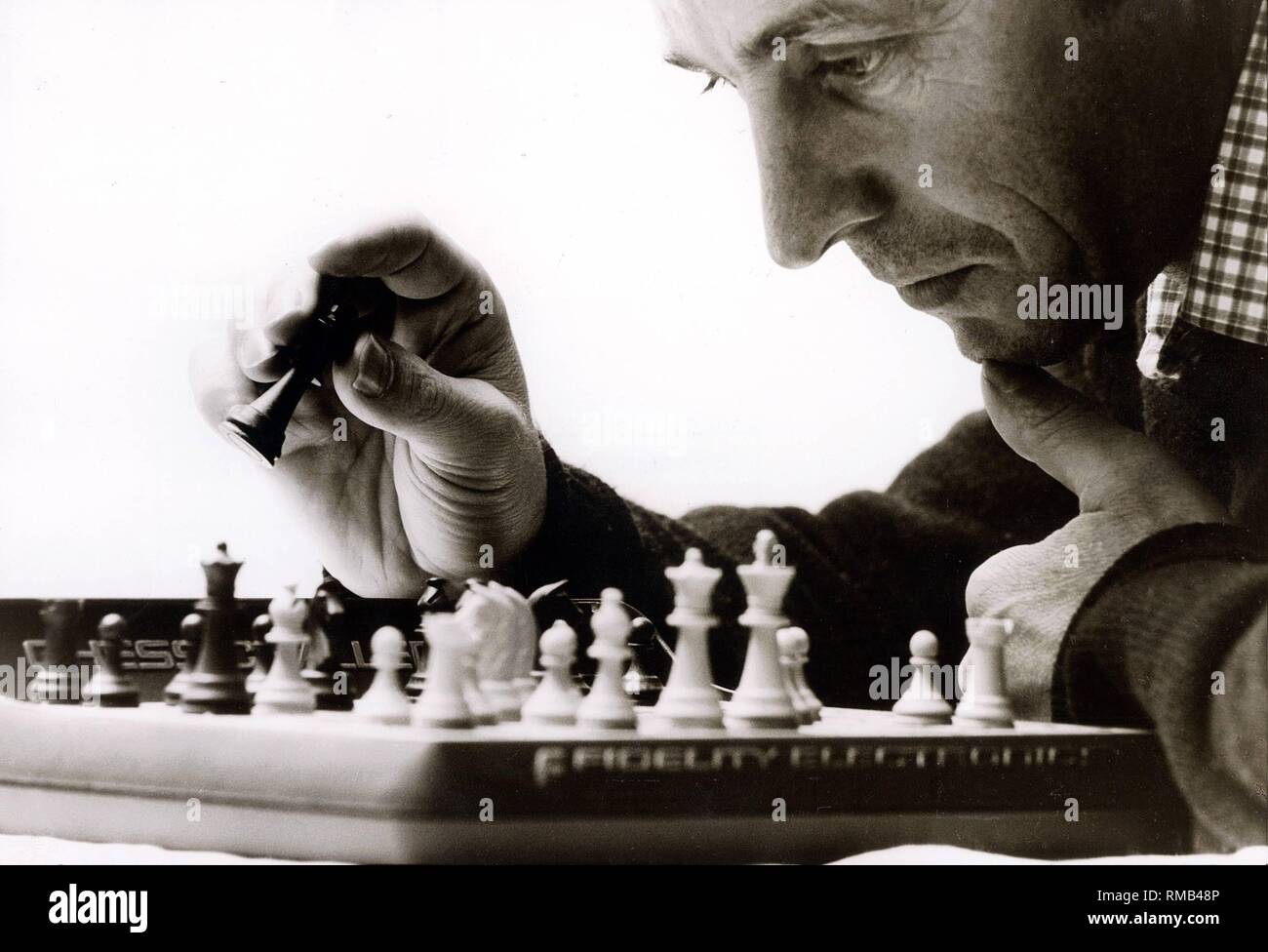Concentration during a chess game with the computer 'Chess Challenger', 1981. Stock Photo