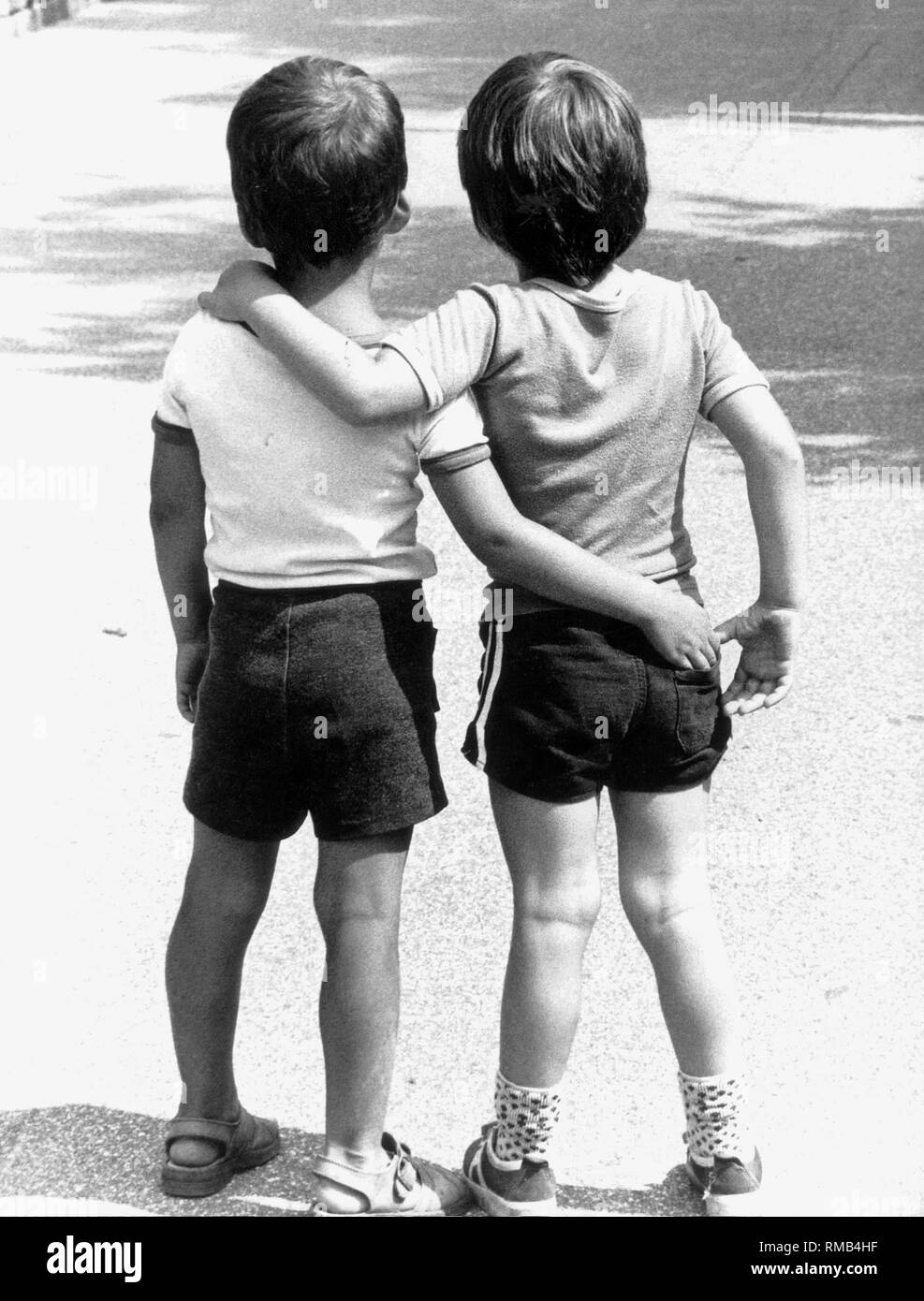 Two little boys arm in arm from behind Stock Photo Alamy