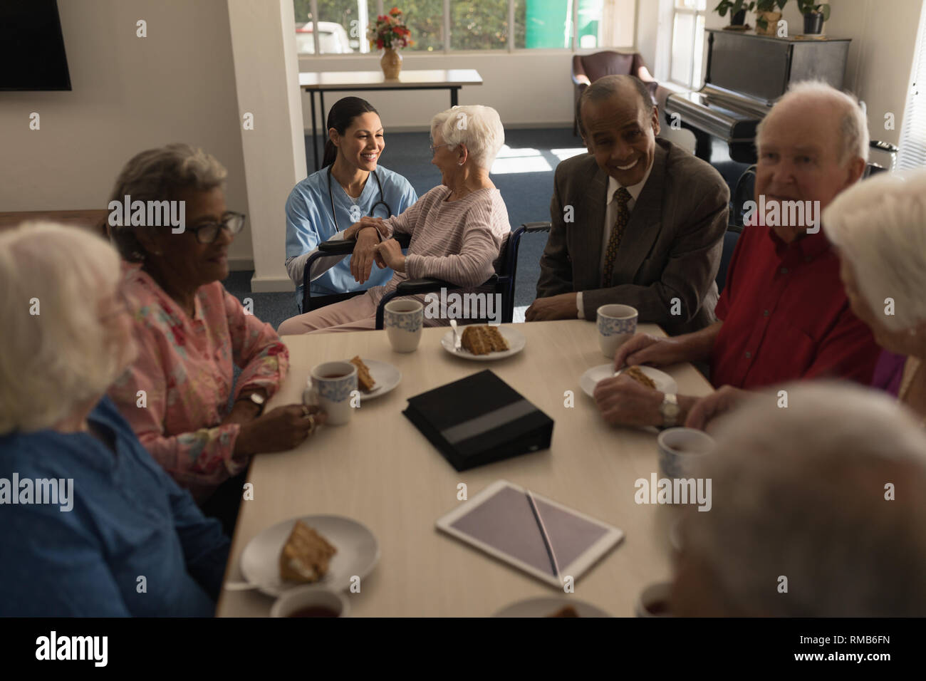 Group of senior friends having breakfast on dining table at nursing home Stock Photo