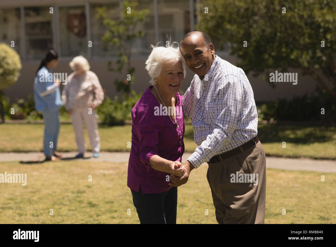 senior couple dancing together in garden Stock Photo
