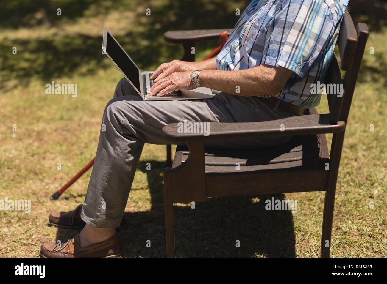 Senior man using laptop in the park Stock Photo
