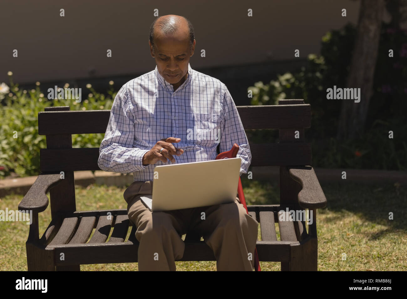 Senior man using laptop in the park Stock Photo