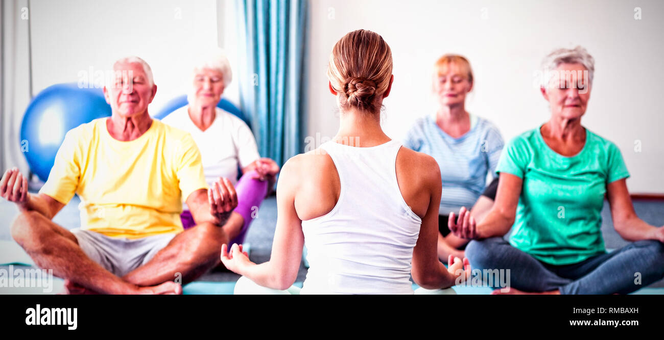 Instructor performing yoga with seniors Stock Photo