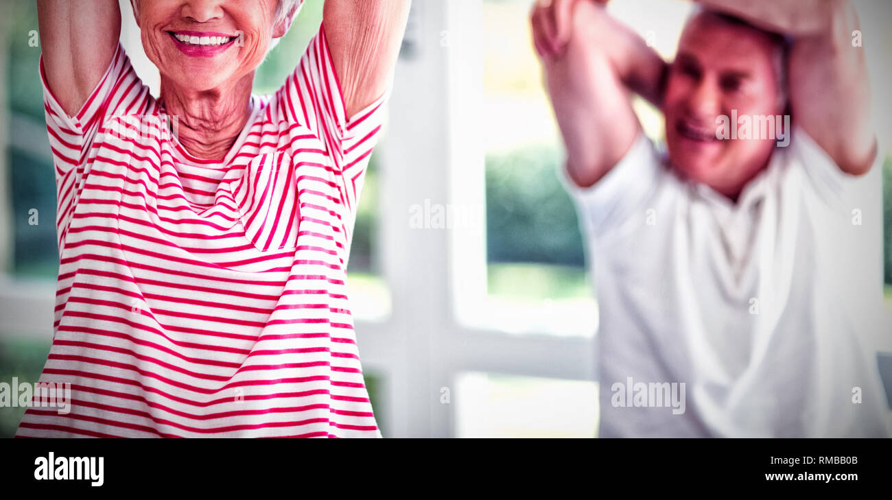 Senior couple performing stretching exercise at home Stock Photo - Alamy