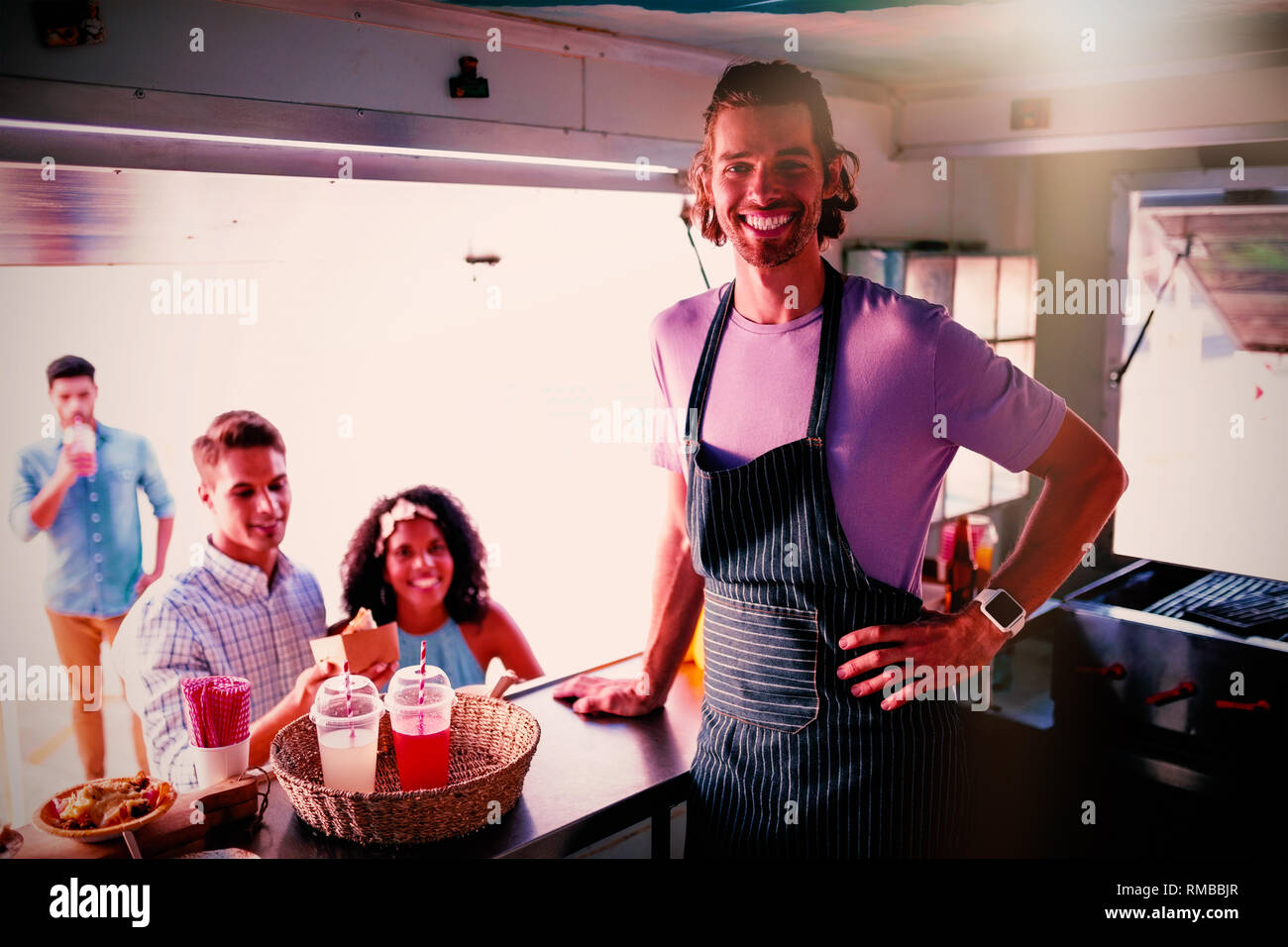 Customers and waiter standing at food truck counter Stock Photo