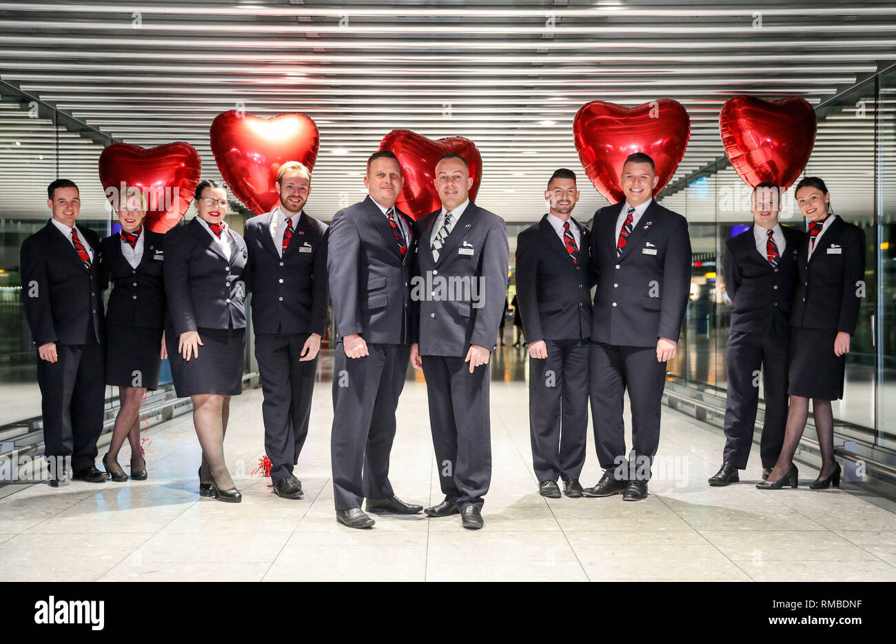 (Left to right) British Airways cabin crew Joshua Halsall, Natasha Holliday, Aimee Anders, Christopher Coyne, Nathan Weekes, Carl Bloor, George Glanvill, Samuel Shervill, David Fisher and Emma Humberstone, who are also couples, pose for a photograph at Heathrow's Terminal 5 prior to departing on their flight BA245 to Buenos Aires, where they will spend Valentines day enjoying a romantic getaway in the Argentinian capital. Stock Photo