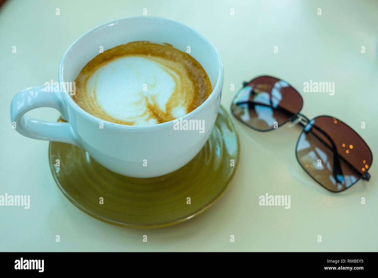 Close up view of office table top with coffee cup and sunglasses Stock Photo