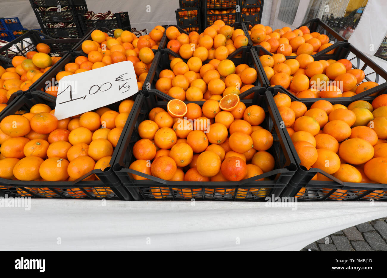 boxes full of ripe oranges for sale at supermarket with label price