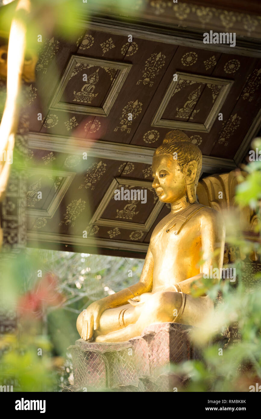 Golden Buddha statues sitting in a garden at Wat Xiengthong in Luang Prabang, Laos. Stock Photo