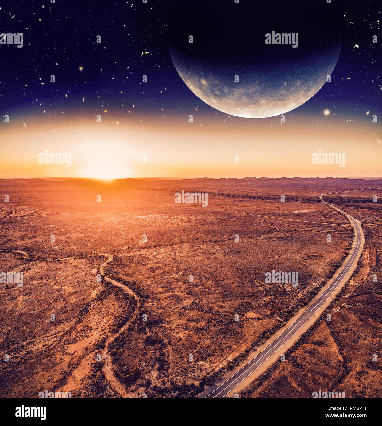 Unreal landscape - dark planet over road winding through desert landscape at sunset. Elements of this image are furnished by NASA Stock Photo