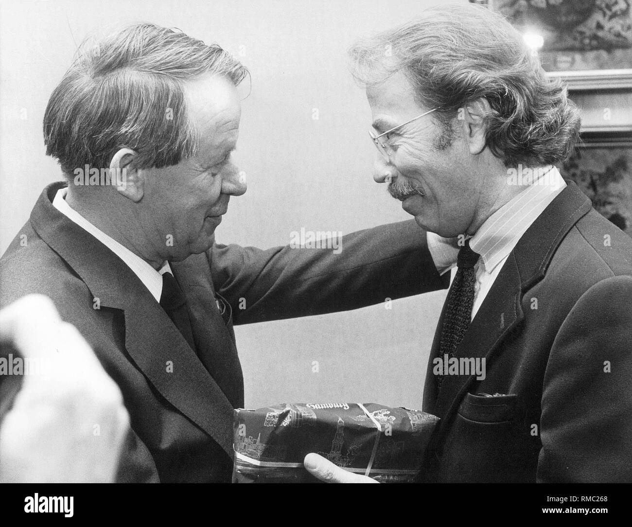 The writer Walter Kempowski (right) congratulates his colleague Siegfried Lenz on his 60th birthday. Stock Photo