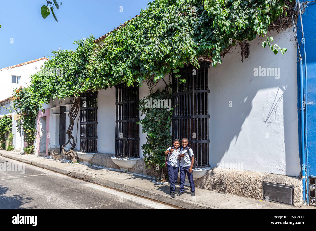 Two school kids in uniform strike a pose on a street, Cartagena de Indias, Colombia. Stock Photo