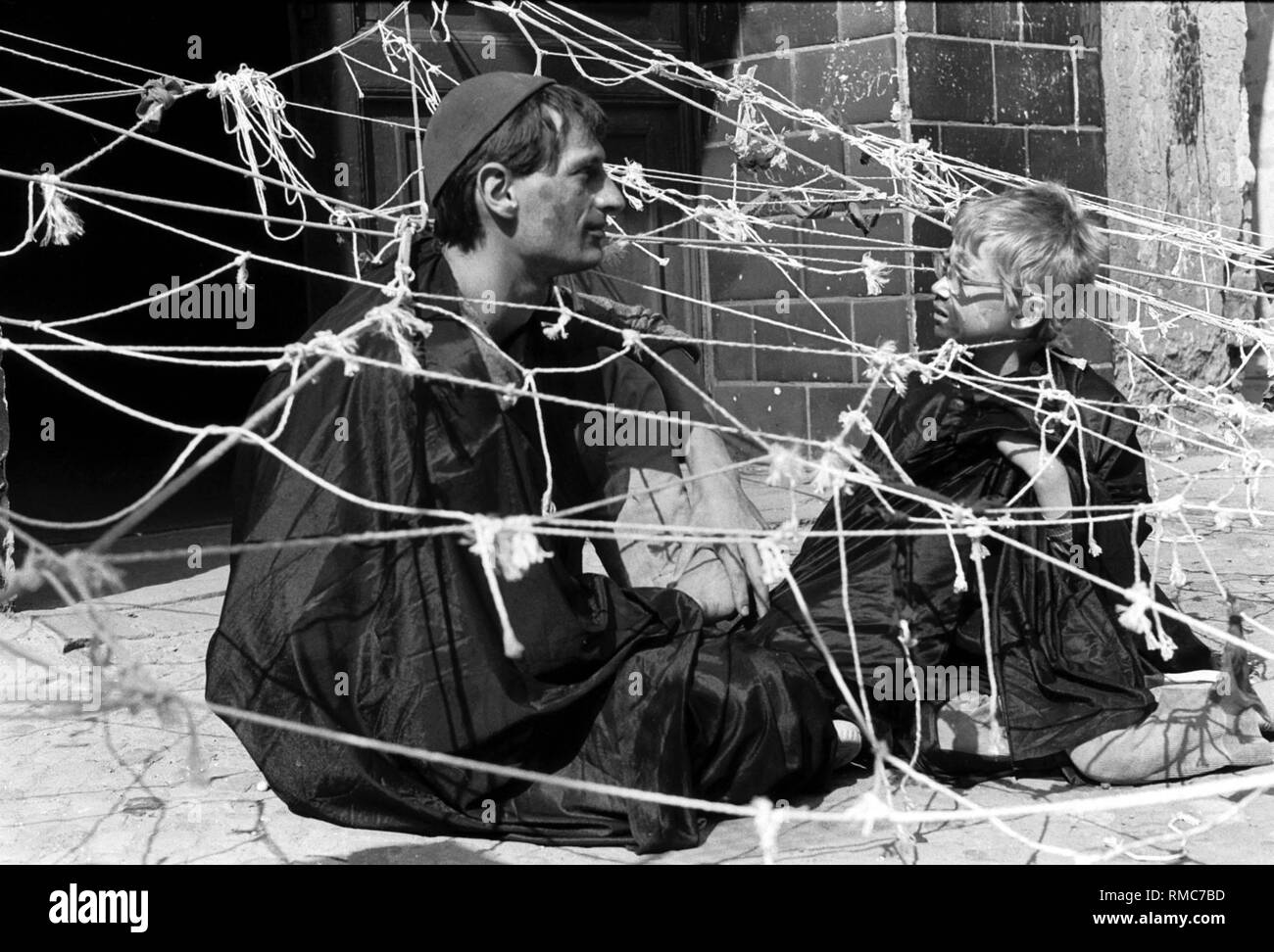 Germany, Berlin, July 11, 1987, the 14th Grammar School in Prenzlauer Berg, a group of people doing fantasy games with children, outside state regulations, Sredzkistrasse, man with child in a net. Stock Photo