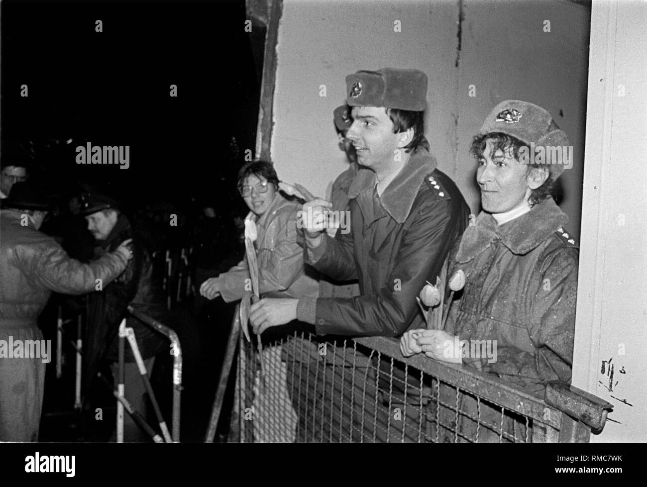 Germany, Berlin, December 22, 1989: opening of the Wall at the Brandenburg Gate. Border guards (inside) with flowers. Stock Photo