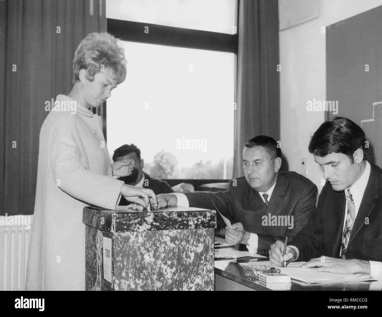 Voters cast their vote at the ballot box. Stock Photo