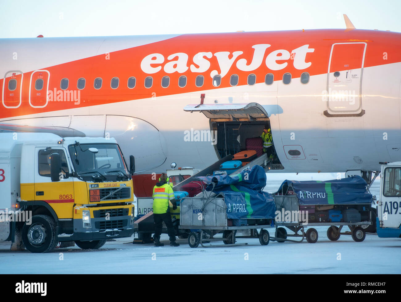 Airport workers removing the luggage bags from an easyJet aeroplane, Kittila airport sign, Kitilla, Finland. Stock Photo