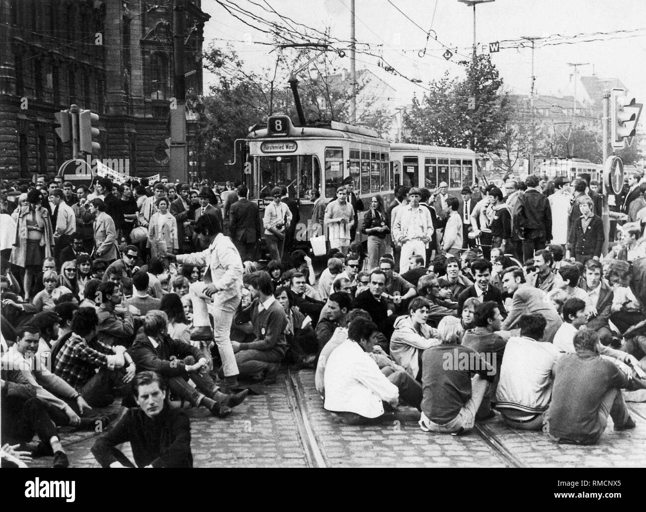 Students block traffic on the Munich Stachus in front of the Justizpalast. A tram of the line 8 also falls victim to the blockade. Stock Photo