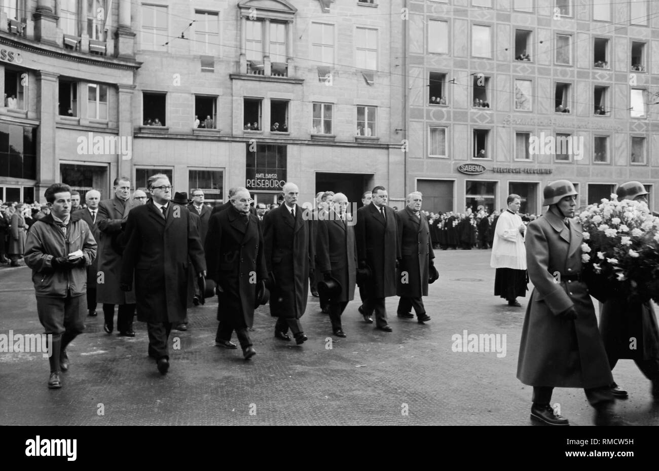 View of the delegation of the CSU at the funeral procession of Cardinal Joseph Wendel, 3rd from left Hans Ehard, 3rd from the right Fritz Schaeffer, 2nd from the right Franz Joseph Strauss. On the left is a photographer. In the foreground, two members of the riot police with a flower bouquet. Stock Photo