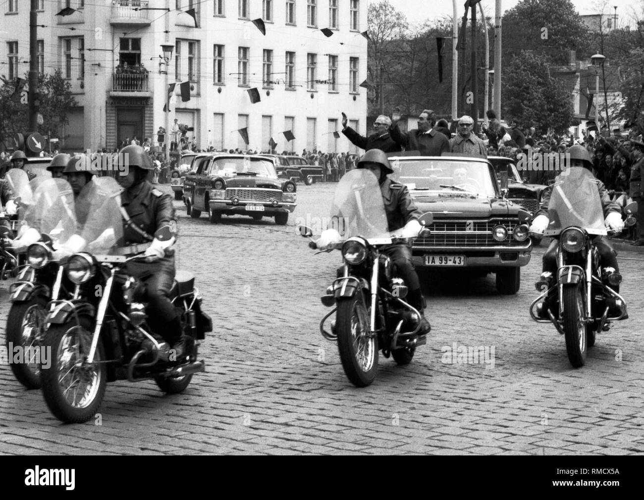 Motorcade with the Soviet party leader Leonid Brezhnev during the state visit in East Berlin in 1973 on the way to the guesthouse of the GDR government Schoenhausen Palace, accompanied by Erich Honecker and Willi Stoph, who waves to the people on the roadside from the open vehicle in the district of Pankow. Stock Photo