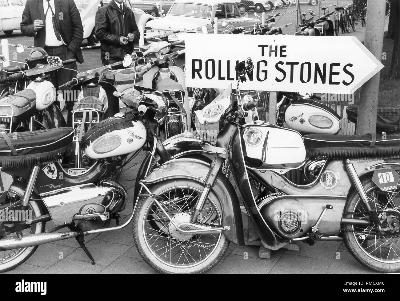 Motorcycles park on an event site, under an information sign pointing to  the concert of "Rolling Stones Stock Photo - Alamy