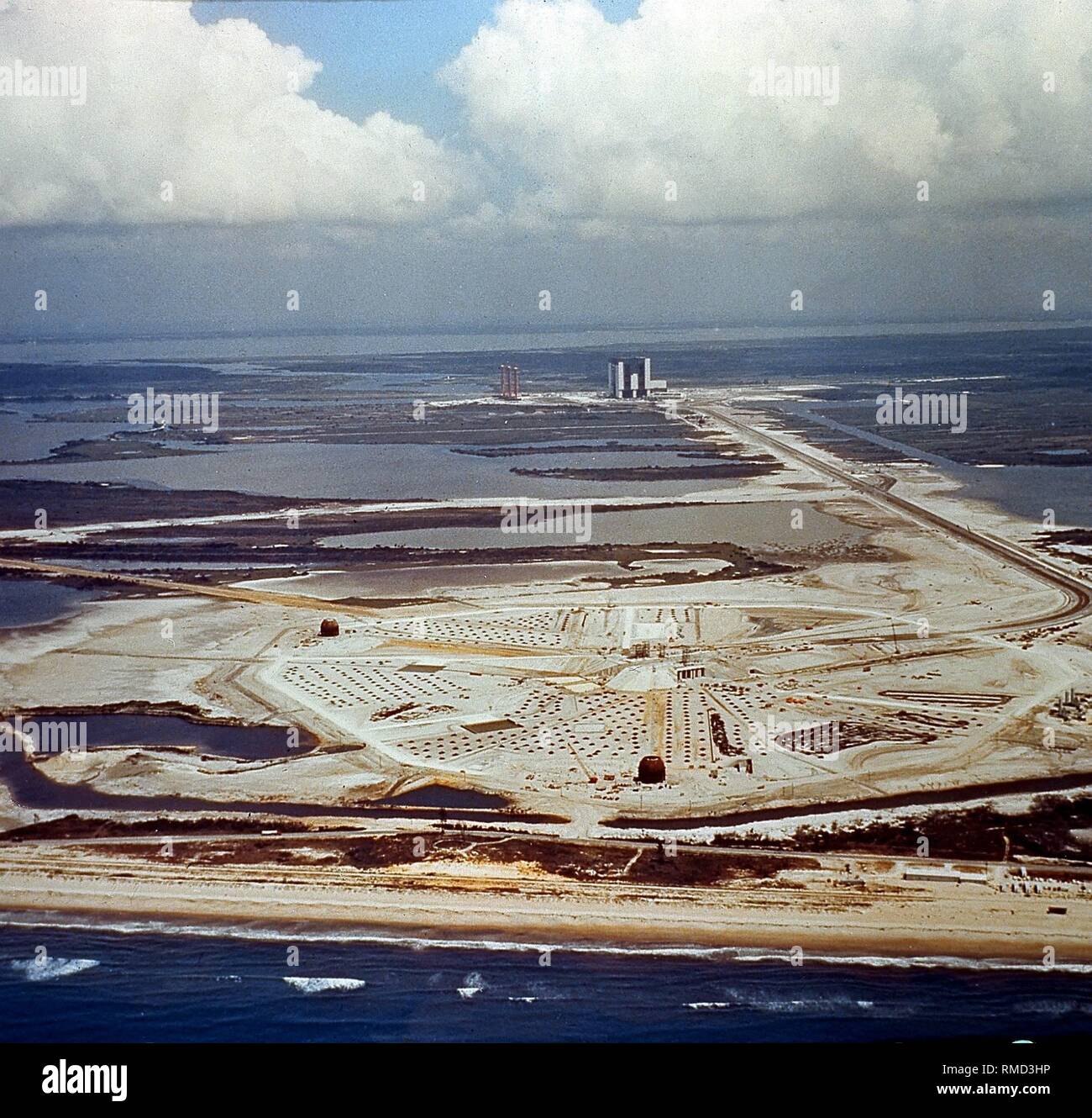 Overview of the Launch Site A of the launch pad at John F. Kennedy Space Center. In the background, the assembly hall for spacecrafts, and to the left next to it, the three mobile rocket launch pads. Undated photo, probably from the 1980s. Stock Photo