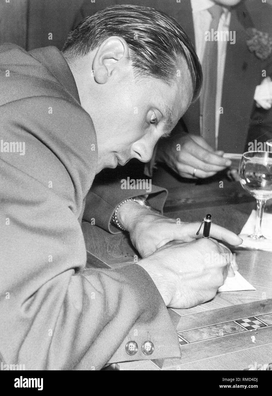 After winning its first World Cup, in 1954 the German national team was invited for a reception in Lindau. Here, Max Morlock gives autographs. Stock Photo