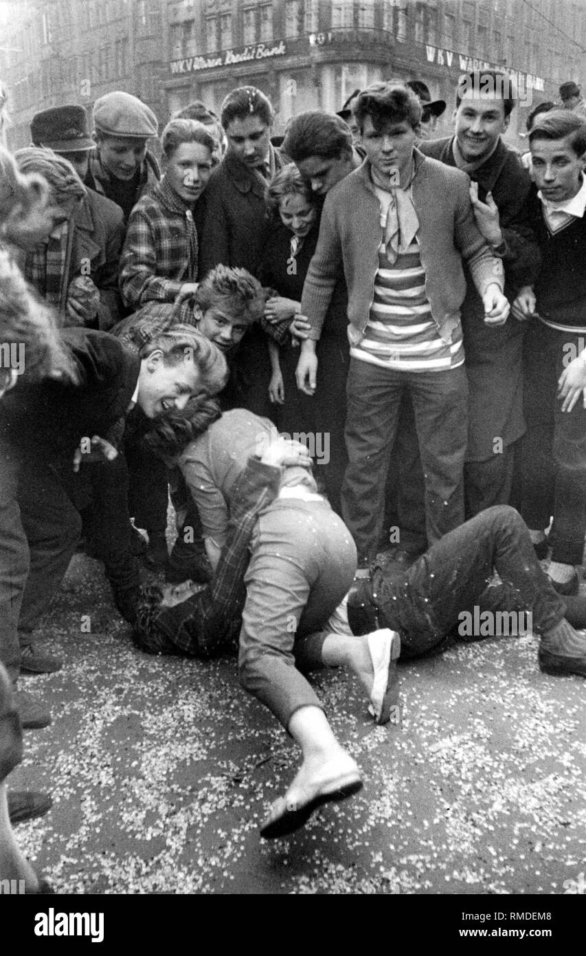During the carnival season in Munich, a boy and a girl compete friendly on the floor, surrounded by teenagers. Stock Photo