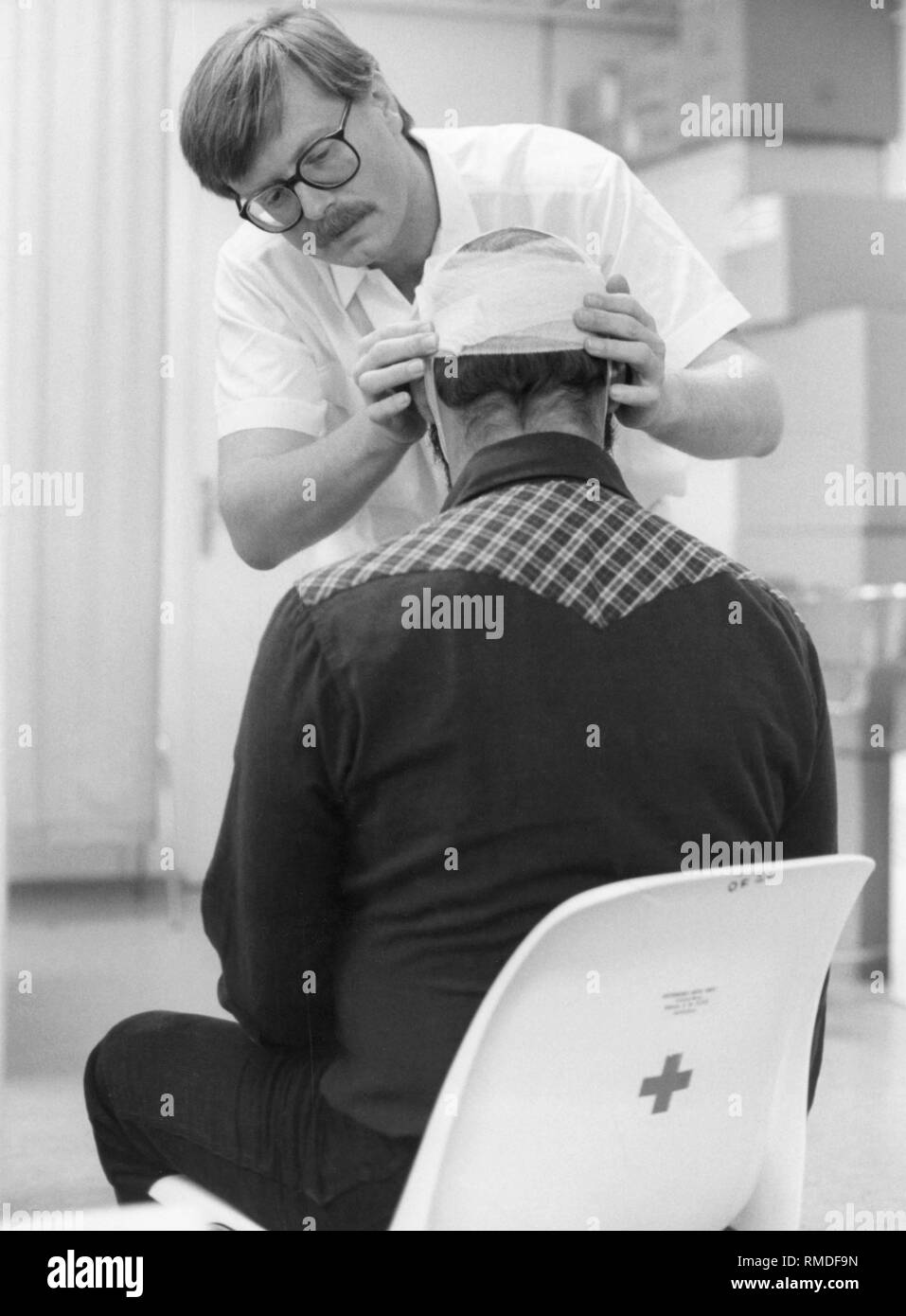 Dr. Eduard Hoecherl, member of the Munich City Council, and later chief surgeon in the Klinikum Schwabing treating an Oktoberfest visitor. Stock Photo