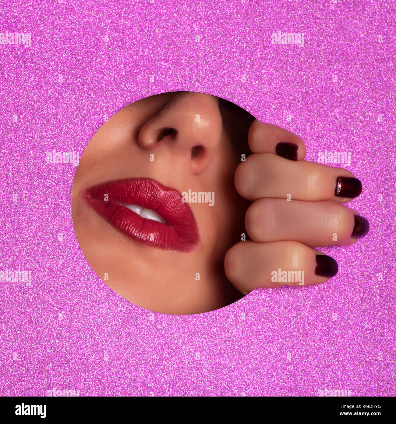 Female fingers, nose and lips with red lipstick through glitter violet