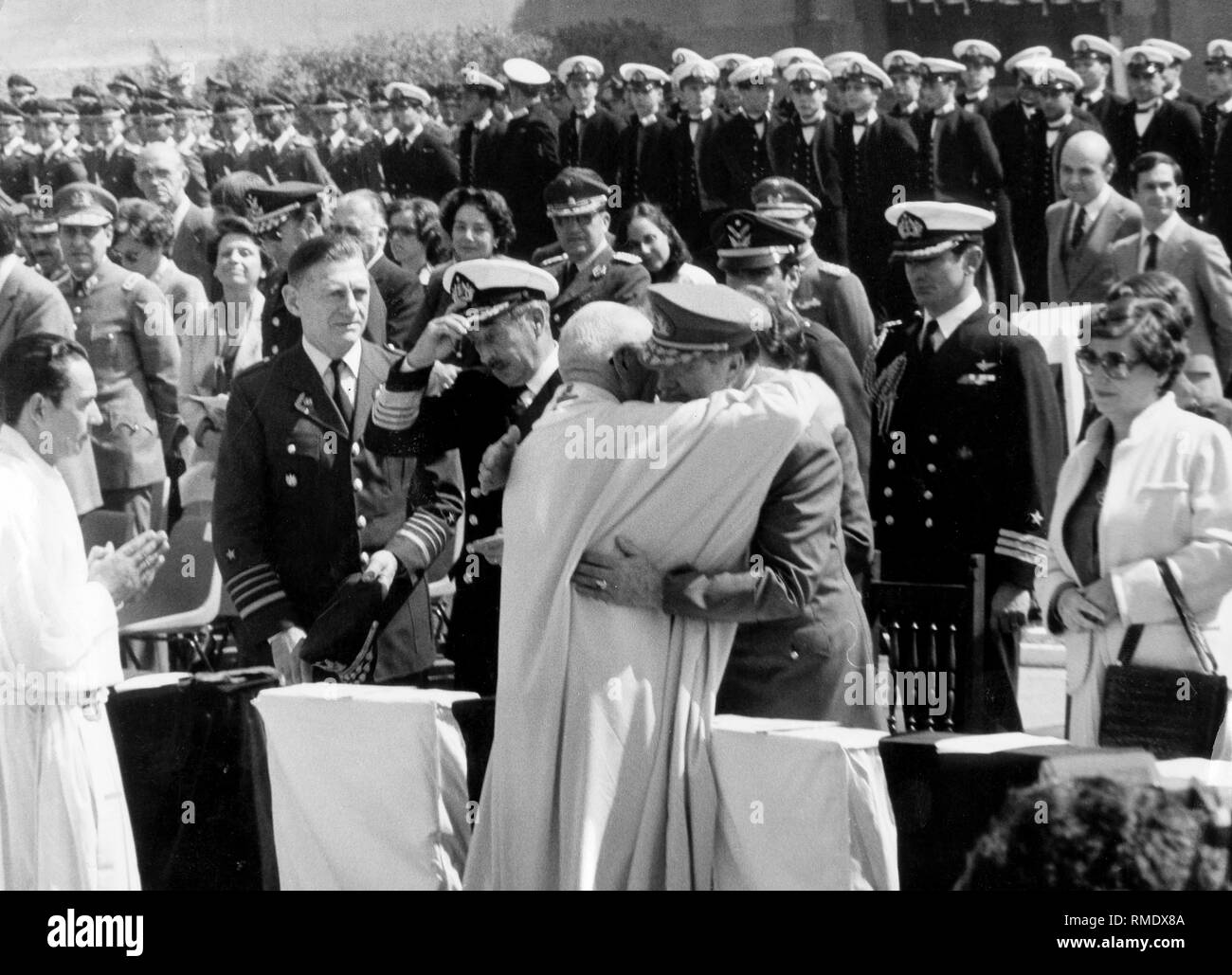 General Augusto Pinochet (r.) embraces the General Vicar of the Army (Military Bishop) Francisco Gillmore at the memorial mass dedicated to the overthrow of former President Salvador Allende. Stock Photo