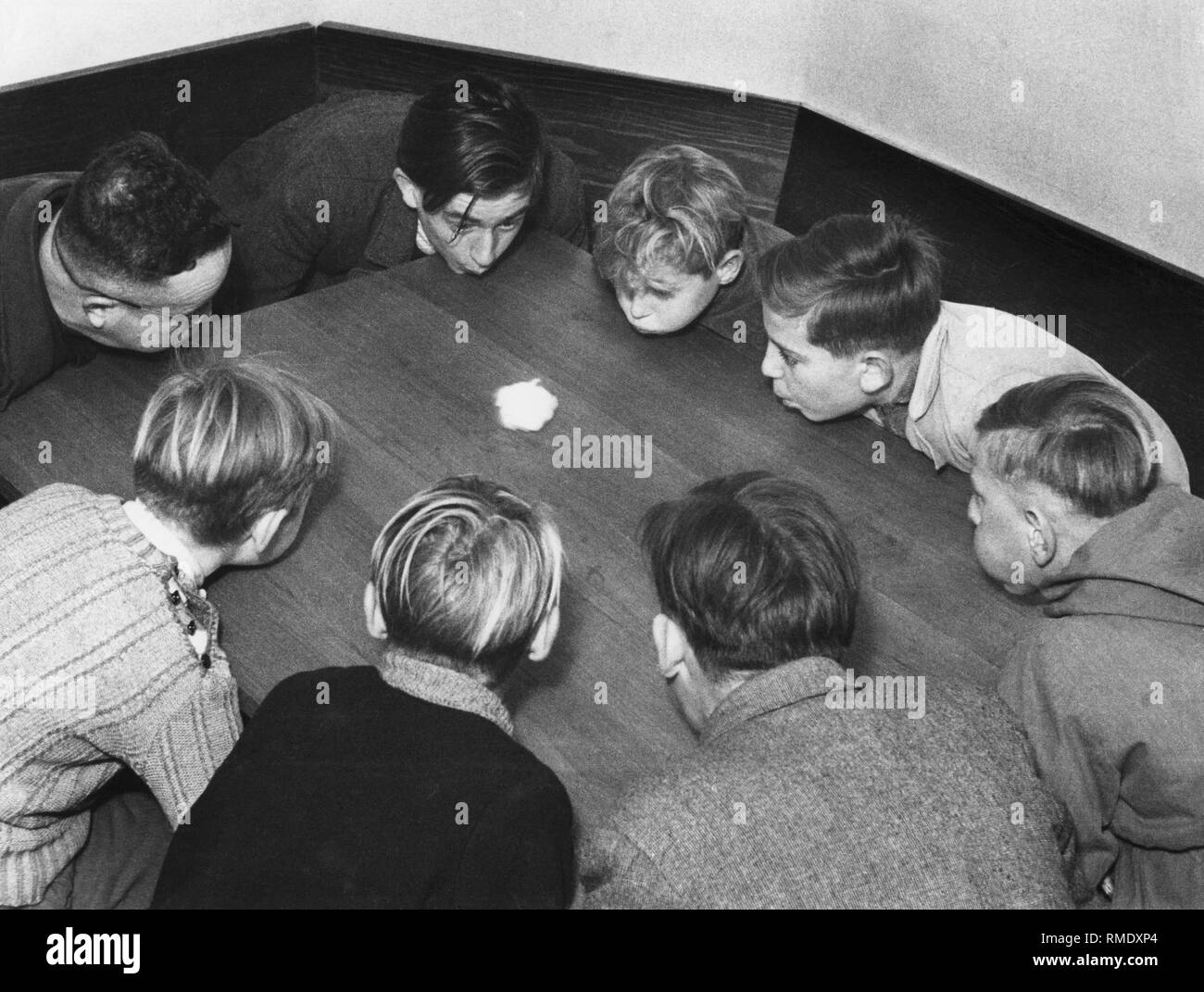 Children blowing cotton balls, 50s Stock Photo Alamy