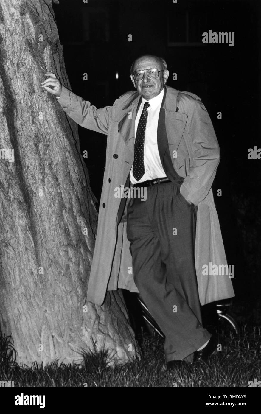 Literary critic Marcel Reich-Ranicki leaning against a tree at night. Stock Photo