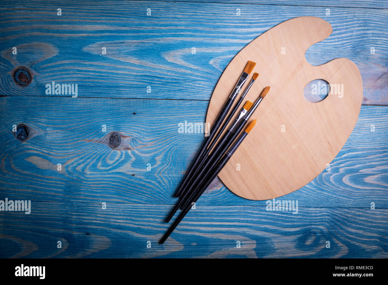 Palette and brushes on a wooden old blue background Stock Photo
