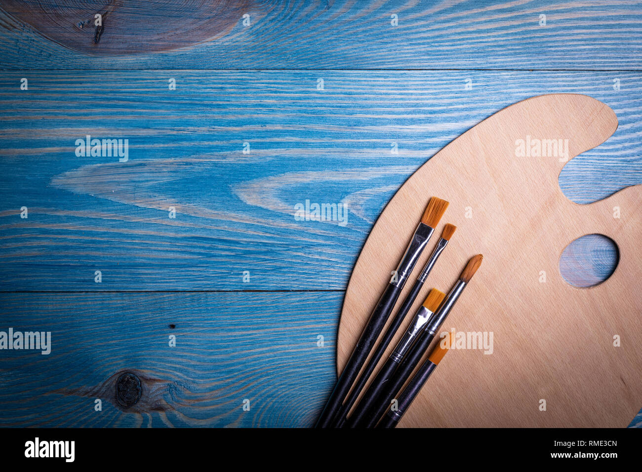 Palette and brushes on a wooden old blue background Stock Photo