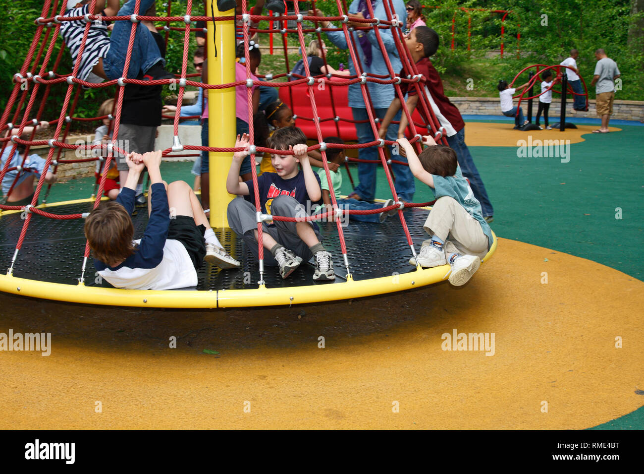spinning jungle gym; playground; fun; soft padded ground; safety; children, boys, girls, different races, motion, Smith Kids Play Place; Fairmount Par Stock Photo