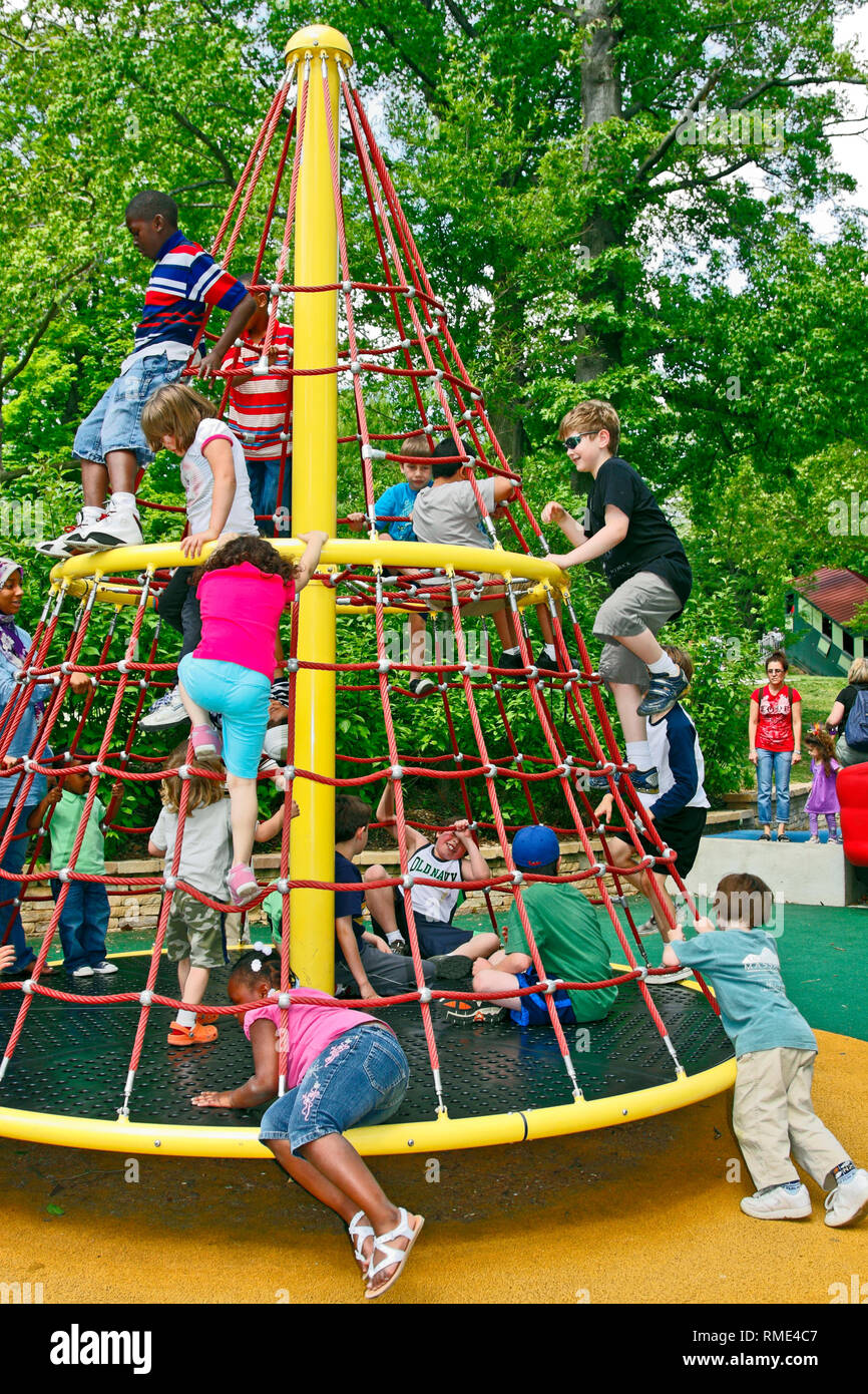 kids playing; spinning jungle gym; playground; fun; energy; active; soft padded ground; safety; different races; children, boys, girls, motion, Smith  Stock Photo