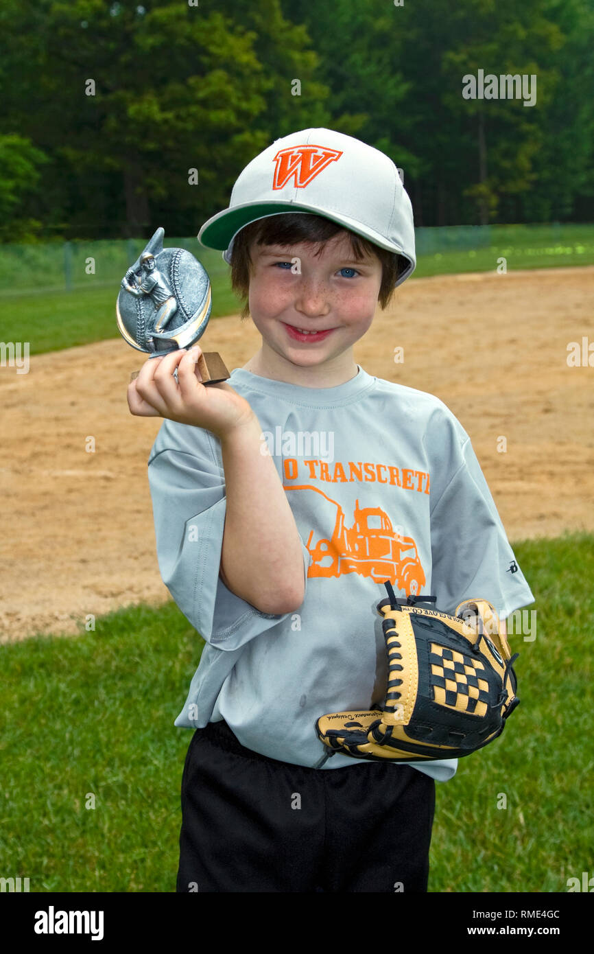 young boy holding baseball trophy; glove; sport; learning