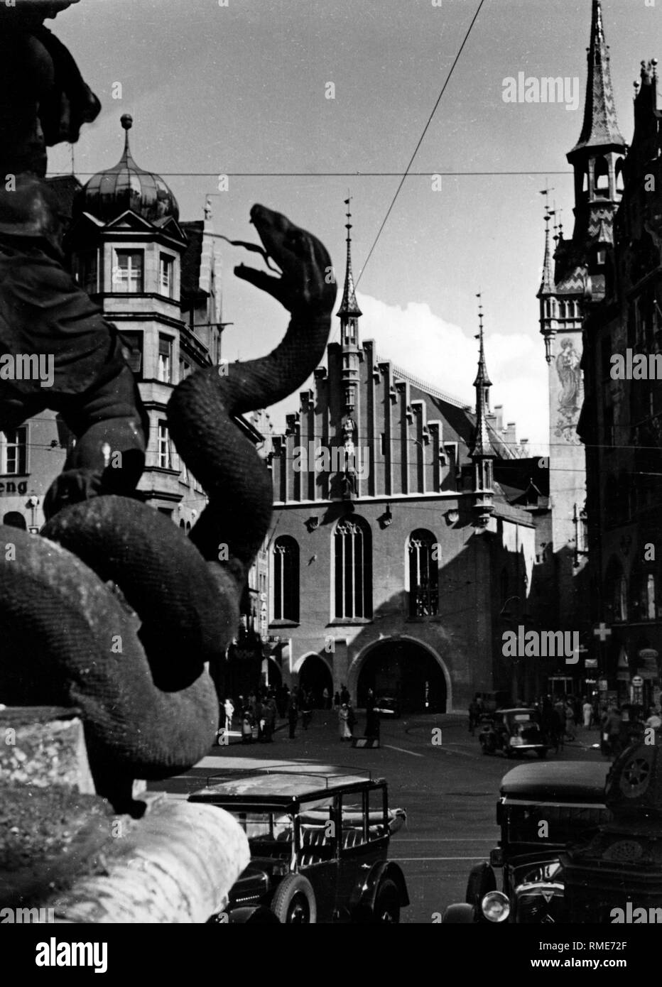 A part of the Mariensaeule (Marian Column), showing a snake, and the Alte Rathaus (Old Town Hall) in Munich. Stock Photo