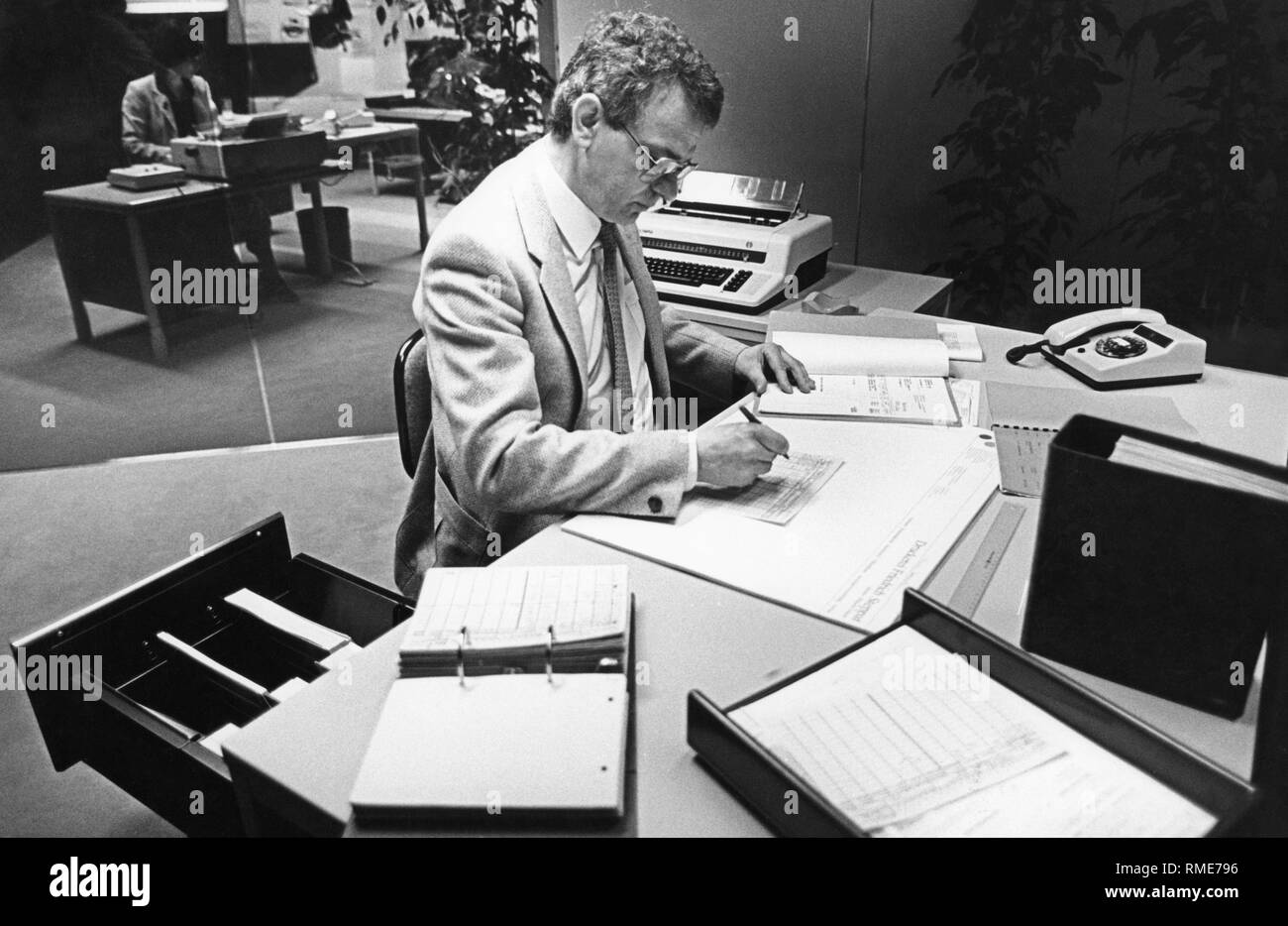 A bureaucrat works at the desk at the special show 'Mensch und Arbeit' at Hannover Messe 81. Stock Photo