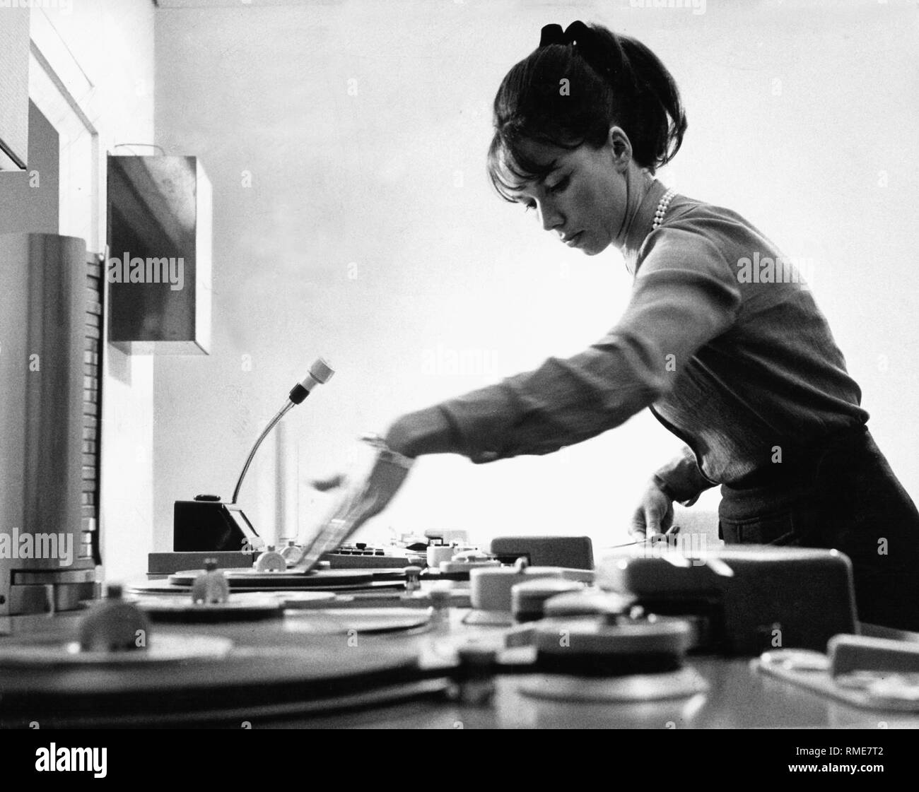 A young woman works at the flatbet editor to edit film material for television. Undatet picture. Stock Photo