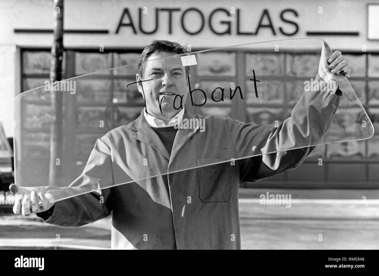 Car glazier Walter Naessl from Munich with a windshield for a Trabant 601. After the opening of the GDR border to the Federal Republic, many workshops began to store spare parts for Trabants and Wartburgs. The windscreen made of laminated glass cost 199 DM plus VAT and installation. Stock Photo