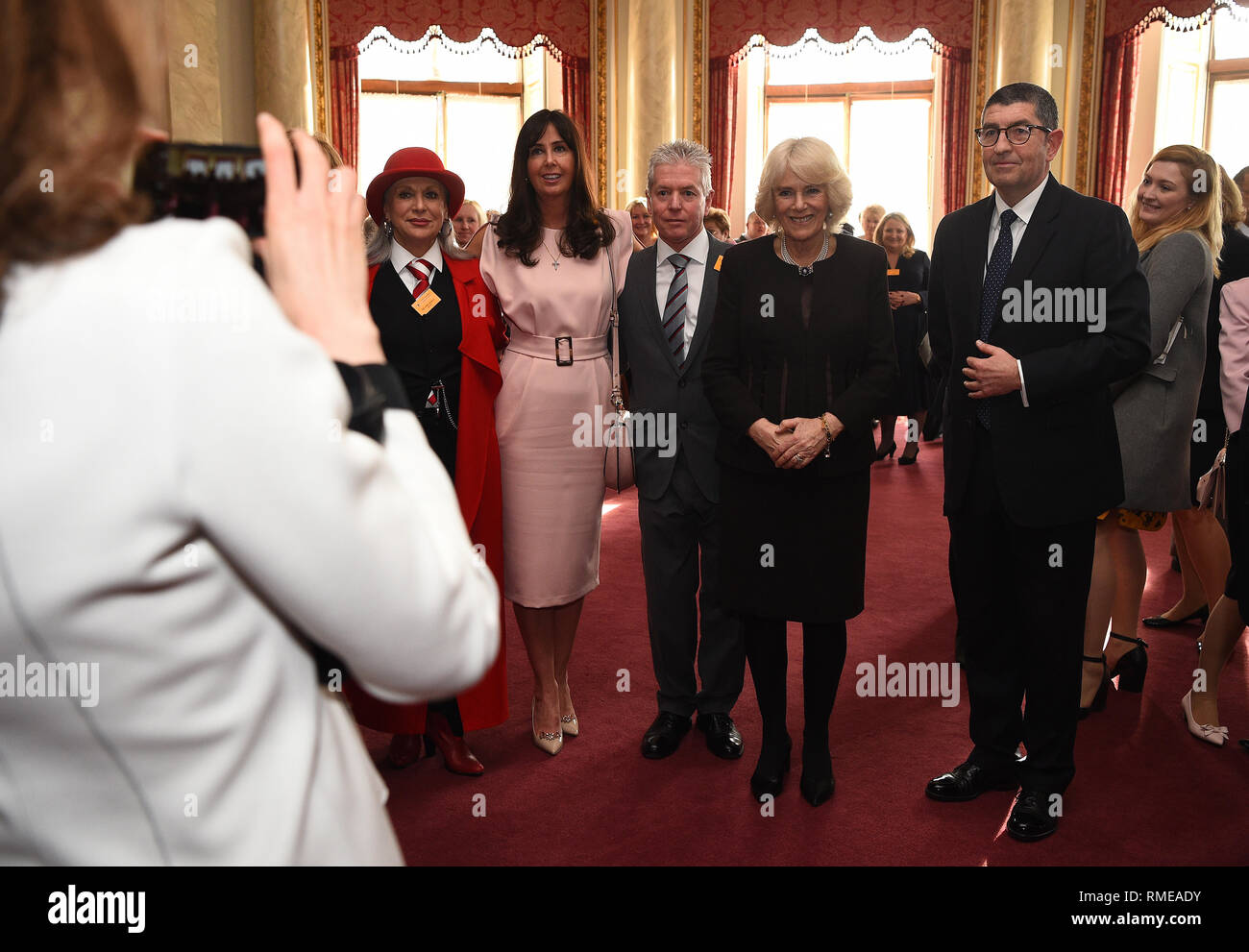 The Duchess of Cornwall poses for a photograph with members of the London Taxi Driver's Charity for Children at Buckingham Palace in London. Stock Photo