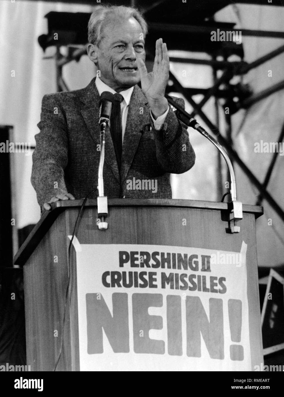 The SPD chairman Willy Brandt as the main speaker at a peace rally. At his lectern hangs a banner with the inscription 'Pershing II Cruise Missiles NO!'. Stock Photo