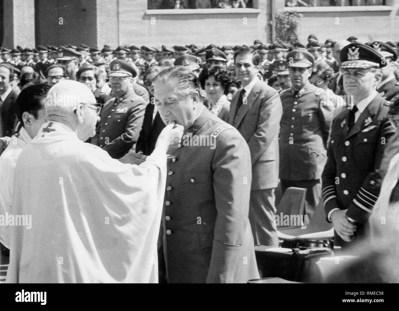 General Augusto Pinochet receives communion at the memorial mass dedicated to the overthrow of former President Salvador Allende. Stock Photo