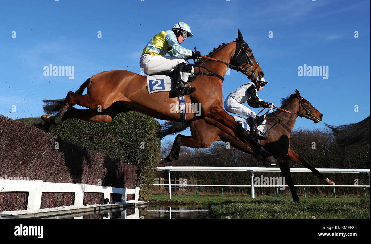 Knockmaole Boy ridden by Hugh Nugent (left) and Militarian ridden by James Martin (right) jump the water jump during The Fernie Steeple Chase at Leicester Racecourse. Stock Photo