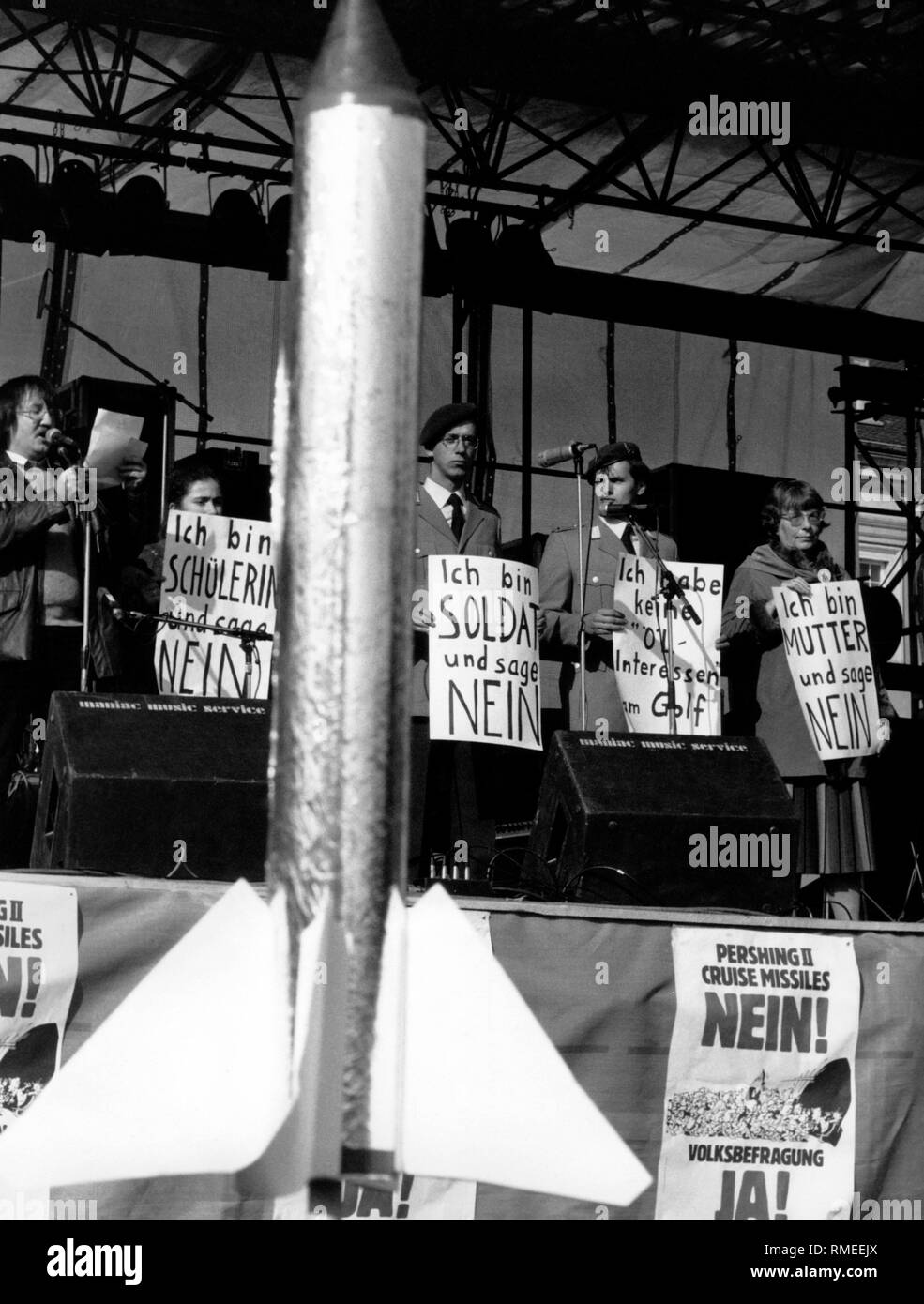 At a rally against nuclear arms are soldiers in uniform in the stands with signs: 'I'm a soldier and I say no.' Stock Photo